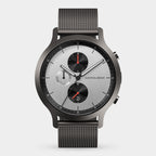 Minimalist silver chronograph watch with black mesh strap, three subdials, and red accents.