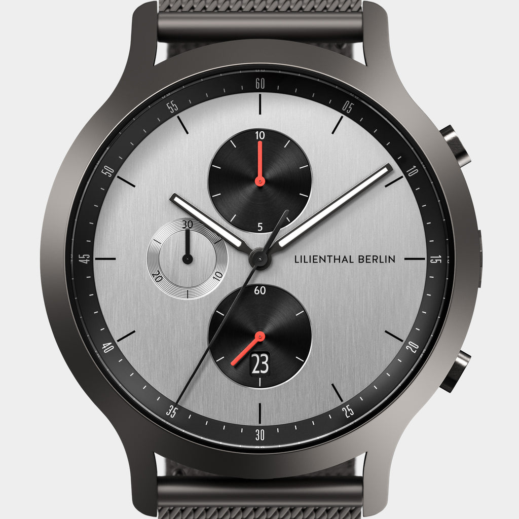Silver chronograph watch with black subdials, mesh strap, and date display