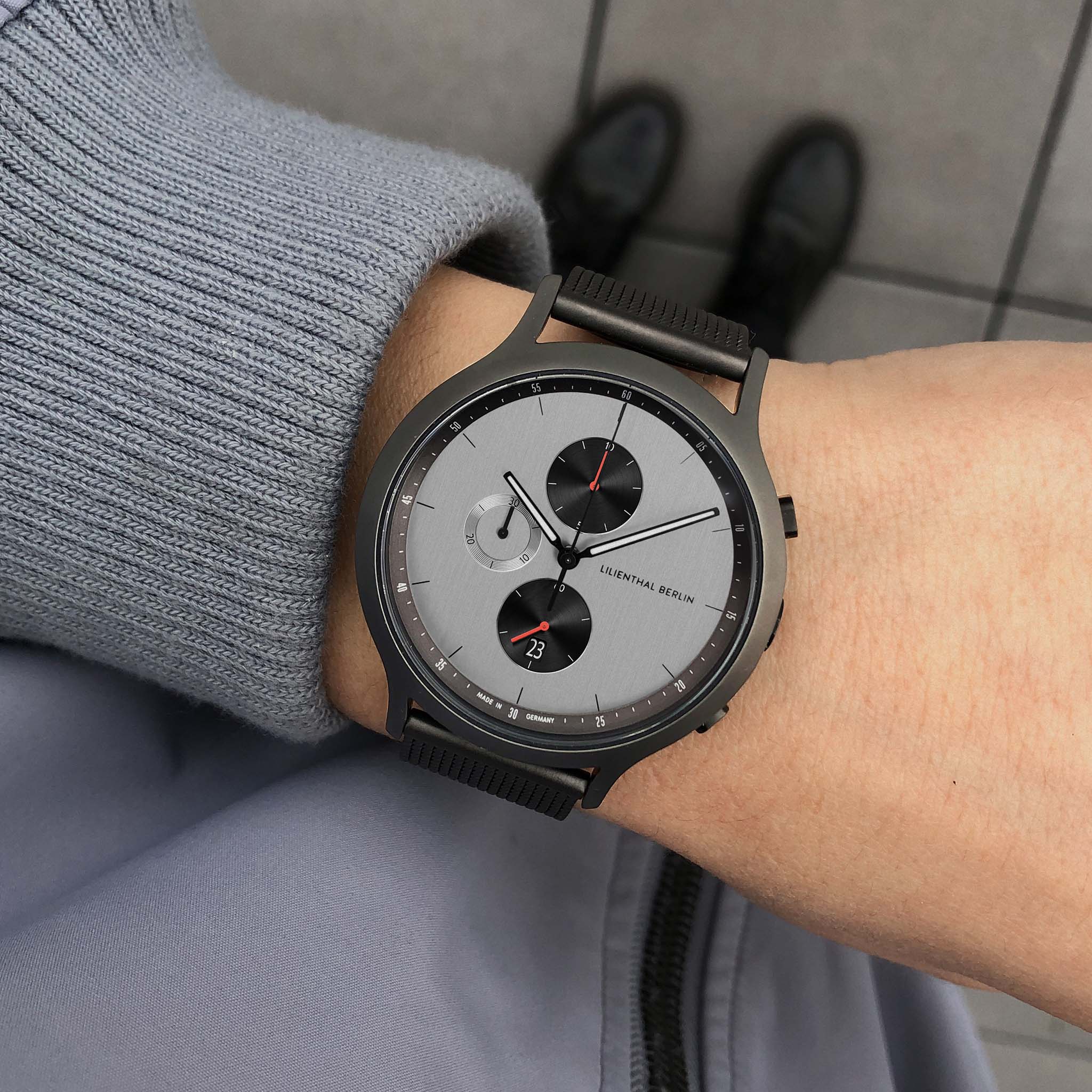Modern chronograph wristwatch with grey dial and black accents worn on wrist