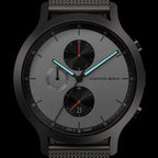 Minimalist black and silver chronograph watch with mesh strap, subdials, and blue hands