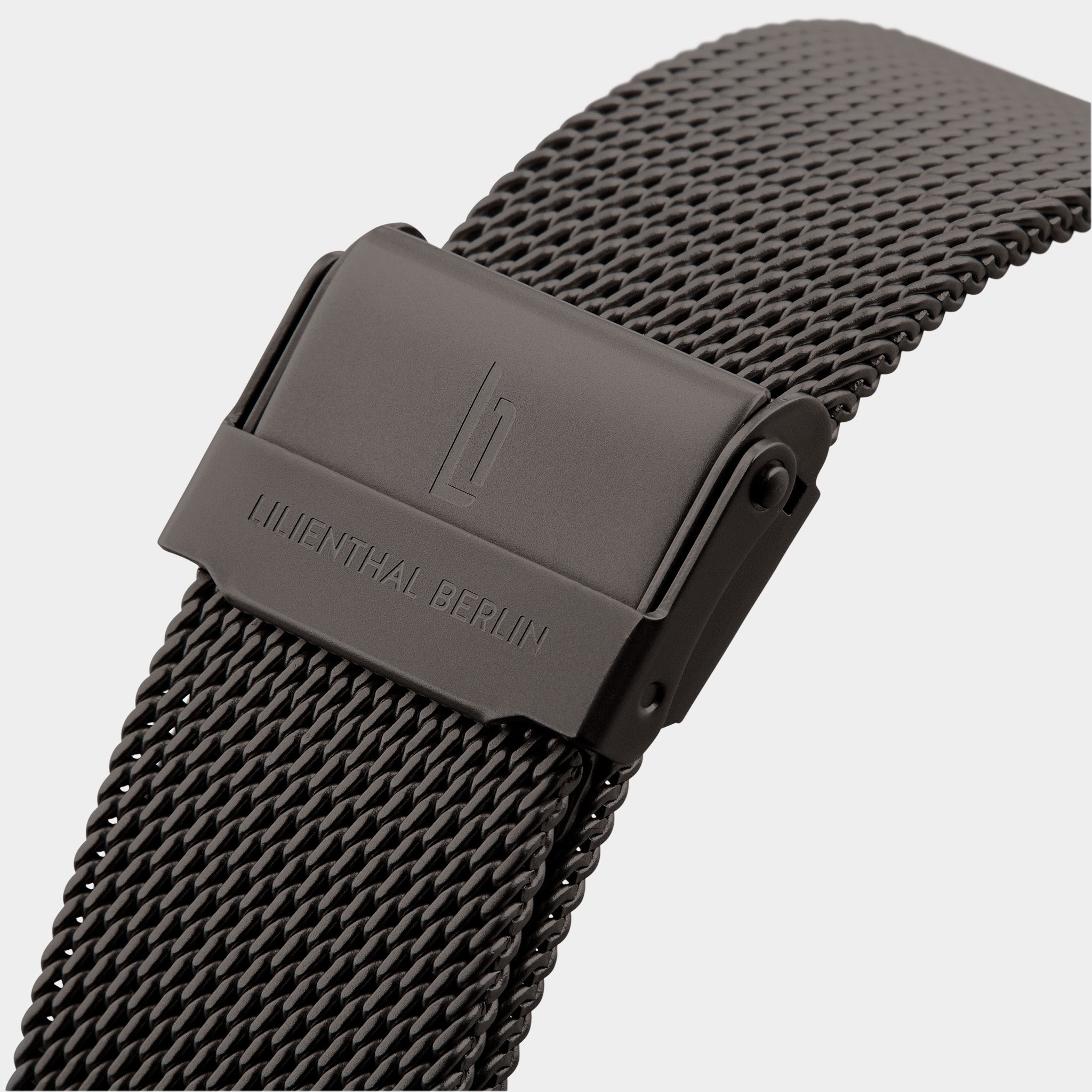 Close-up of black stainless steel mesh watch strap with secure clasp