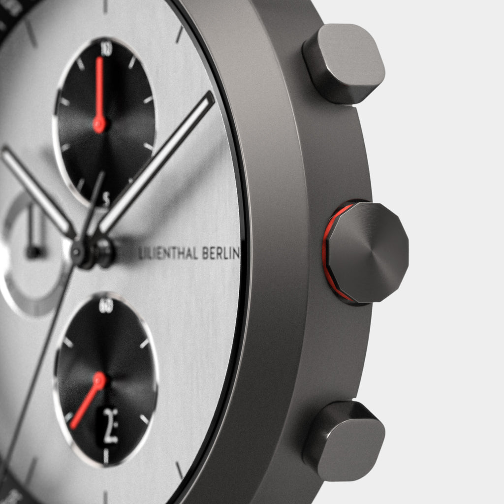 Close-up of modern chronograph watch with subdials, brushed metal case, and red accents