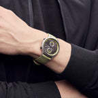 Modern wristwatch with green strap and black-yellow dial on person's wrist, close-up