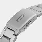 Close-up of a stainless steel watch bracelet clasp with engraved logo and brushed metal finish