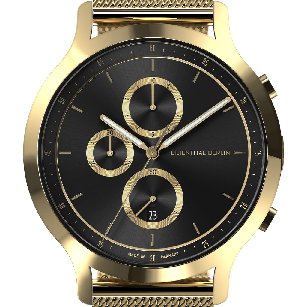 Gold chronograph watch with black dial, mesh strap, and date display