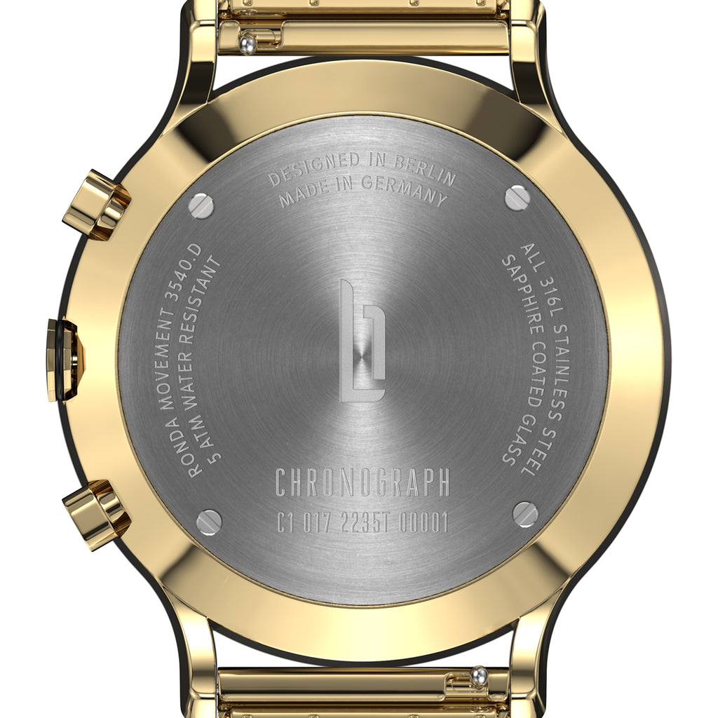 Close-up of gold chronograph watch case back with steel engraving and branded logo