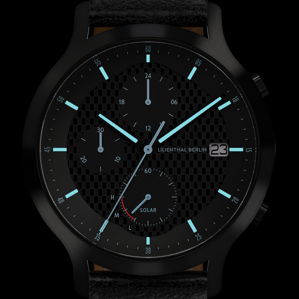 Black analog solar watch with luminous hands, subdials, date display, and textured face
