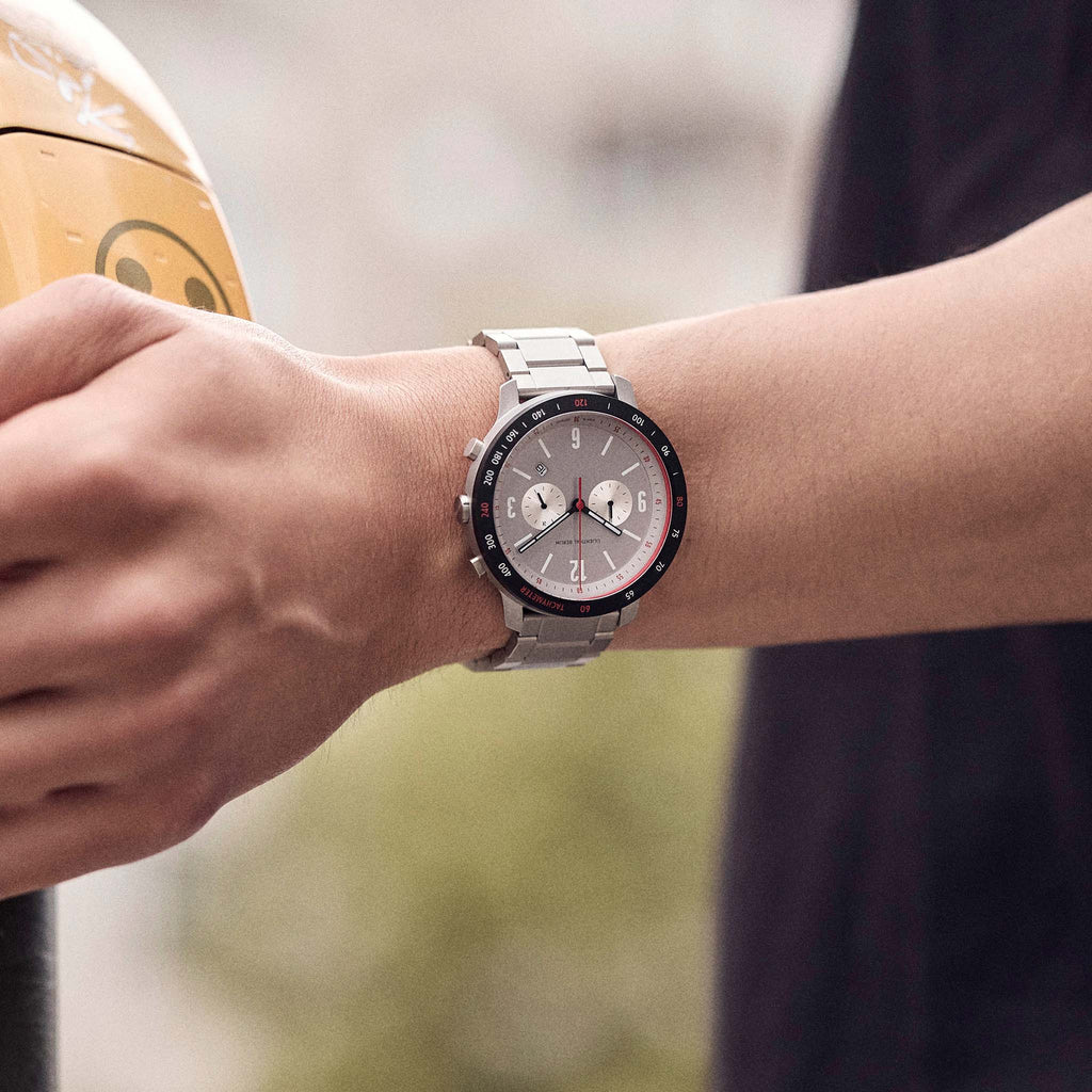 Stainless steel chronograph watch with silver dial worn on wrist outdoors