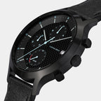 Black solar chronograph watch with textured dial, subdials, date window, and leather strap